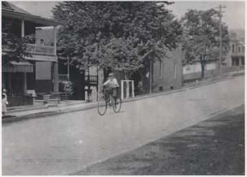 An unidentified boy rides down the street near the Eighth Avenue intersection.