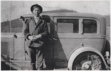 Adkins pictured beside an automobile.