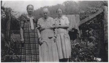 Mary Ballengee Hicks, Sara Ada Buckland Wickline and Ballengee's daughter are pictured beside hanging laundry.