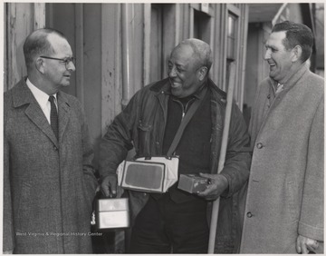 The C. & O. engineer Burdette, pictured on the far right, laughs beside two unidentified men. 