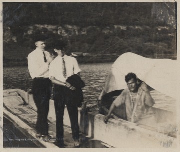 Foy and Fred Meador stand on the dock beside a ferry. 
