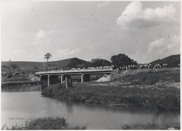 A crowd scatters across the newly constructed bridge. 