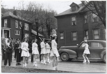 Marching band gets in position on the corner of Fourth Avenue and Ballengee Street. Ann Harvey Gore's parents home pictured on the far right. 