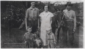 From left to right standing is Forest Noel, Lena Noel and Henry Noel Senior. Tommy James and Henry Jr. are sons of Forest and Lena, two of which are pictured with the dog.