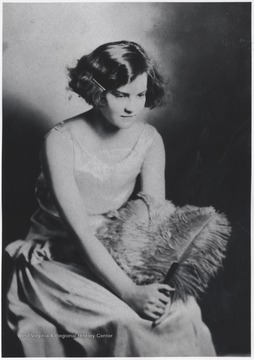 Johnson pictured in fashionable attire holding a feather. 
