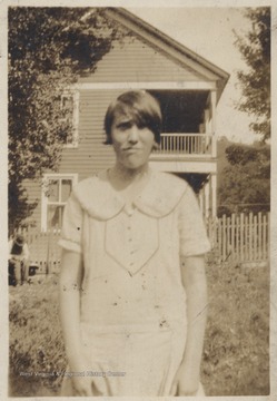 Shumate pictured wearing a dress outside of her old home.