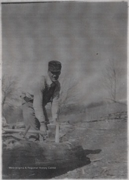 Shumate pictured pulilng an ax from a log.