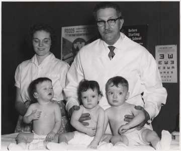Stokes and nurse Pati Ames stand behind three young children in the Summers County Health Department. 