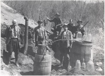 Revenuers, also known as "revenooers", inspect the illegal distillery located in the middle of the woods.