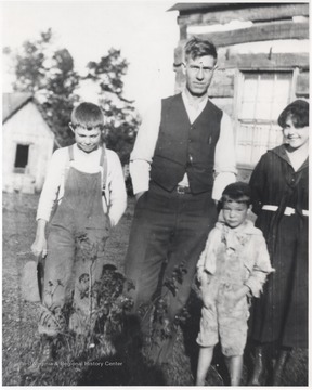 Della (right) with two young boys and man, identified as John Bragg, outside of a home located in the Bluestone River Valley.