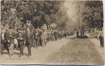 A. S. O. students march alongside the wagon of newlyweds. Subjects unidentified.