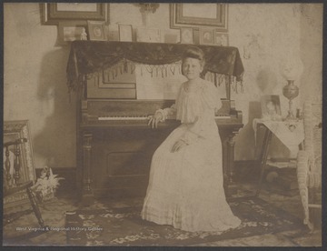 The unidentified family members leans against her photo-covered piano.