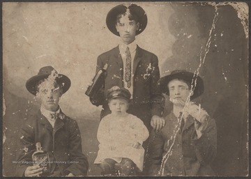 Robert Neely is likely the young man to the far left holding the whiskey bottle. R. P. Neely is the baby sitting in the center of the photograph. 
