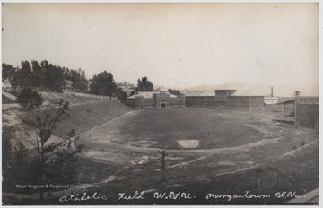 View of the field which is now where the MountainLair is located. In the background is the Armory and to the right of that is Mechanical Hall, which burned down in 1956. To the right is Commencement Hall, with grandstand attached to the back. To the left and up the hill is Stalnakar Hall.