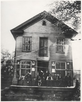 A group of men sit on the deck of what was the first store to be built in Hinton. Located in the Avis section of the cit, the building is now where the Sears Rosebuck parking lot is today.