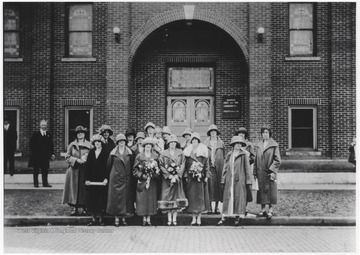 A group of women pose in front of the church entrance. Subjects unidentified.