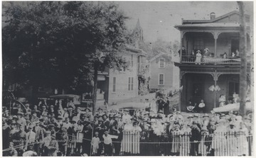 A crowd gathers outside of the park to celebrate soldiers who fought in World War I. In the background, Miller Hotel is pictured to the right. 