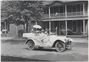 A family crowds inside the car decorated for the event on Temple Street. Subjects unidentified. 