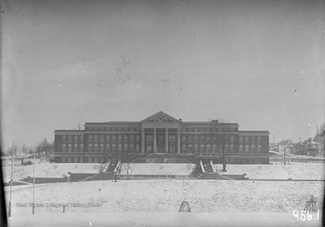 Front view of Women's Hall in the Snow showing a 'beat Pitt' sign