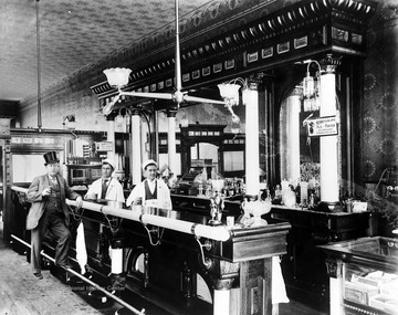 A man in a top hat stands next to the bar.
