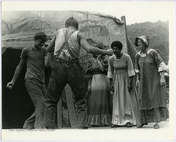 EcoTheater actors Benny Allen, Charlie Haywood, Kathy Jackson, and K. Davis, perform in the play "John Henry" by Maryat Lee in Summers County, W. Va.Maryat Lee (born Mary Attaway Lee; May 26, 1923 – September 18, 1989) was an American playwright and theatre director who made important contributions to post-World War II avant-garde theatre.  She pioneered street theatre in Harlem, and later founded EcoTheater in West Virginia, a community based theater project.Early in her career, Lee wrote and produced plays in New York City, including the street play “DOPE!”  While in New York she also formed the Soul and Latin Theater (SALT), and wrote plays centered around the lives of the actors in the group.In 1970 Lee moved to West Virginia and formed the community theater group EcoTheater in 1975.  Beginning with local teenagers from the Governor’s Summer Youth Program, the rural theater group grew, and produced plays based on oral histories collected from the local community.  Each performance of an EcoTheater play involved audience participation and discussion.  With the assistance of the Humanities Foundation of West Virginia, guest scholars became a part of EcoTheater.