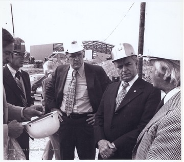 Pictured from left to right is unidentified, MESA administrator James Day, Raleigh County Airport Authority Paul Hutchinson, Senator Byrd, and unidentified. In the background turned away from the photo is Raleigh Country Airport Authority Charles Lewis. The construction site is located on Airport Road.