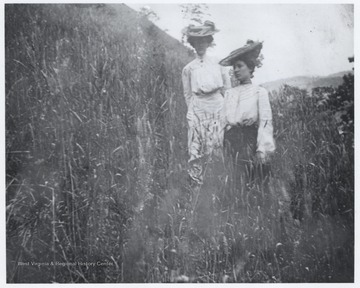 Mrs. Murrell, right, walks through tall grass and is accompanied by an unidentified female. 