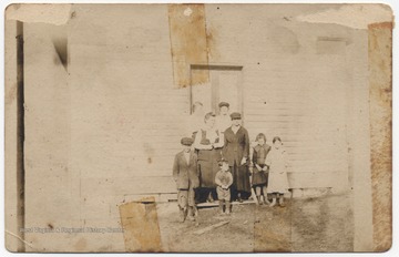 Laura Shumate, a teacher at the school, is pictured with an unidentified associate and school children. 