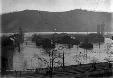 The flooded town is shown with mountains in the background and the "P.R.R. Railroad tracks in foreground." 