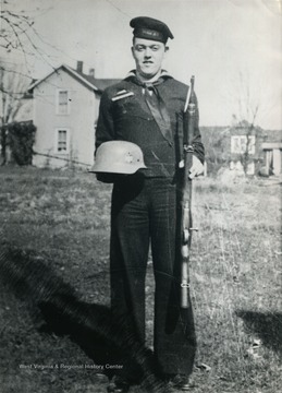 Billy Scott Sirk of West Virginia holds a German helmet while posing in Cherbourg, France after the Normandy Invasion.