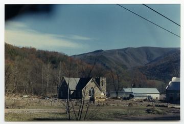 Debris, cars, a damaged bus, and a damaged truck surround a church after the flood that occurred in November 1985 in the area around Parsons, Elkins, Onego, and Mounth of Seneca, W. Va.