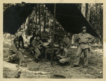 Marshall L. Williamson of W. Va., U.S. Navy Medical Corps, and the 57th Naval Construction Battalion (Seabees) at their camp in Espiritu Santo in the New Hebrides during World War II.A note on the back of the photograph reads: "This time I am the first from the right side. The two pouches on my side are my first-aid bags.