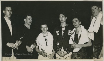 Pictured from left to right is Willie Akers of Mullens High School, Mr. Hurt from Beckley High School, Jack Landers from East Bank High School, Jerry West from East Bank High School, Jay Jacobs from Morgantown High School, and Mr. Davis from Morgantown High School.West was East Bank High School's starting small forward. He was named All-State from 1953–56, then All-American in 1956 when he was West Virginia Player of the Year, becoming the state's first high-school player to score more than 900 points in a season.He team secured the first ever state championship title for East Bank High School's basketball team. 