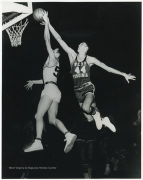 West, the "tallest player in basketball" at 6'3" keeps Smith from successfully making a shot. At this game, West Virginia University handed Kentucky their fifth home defeat in 15 years.Both West and Smith made the United States Olympic team two years later in 1960.