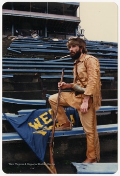 West Virginia University's 1986-1987 mascot poses on Old Mountaineer Field bleachers before demolition.