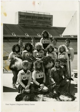 West Virginia University Cheerleaders and the Mountaineer Mascot pose at stadium.