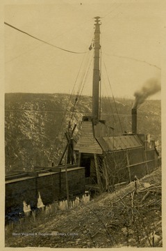 The overhead, or cableway skidder, used several different cables raised at both ends, from the skidder to trees above the loading area, and allowed loggers to raise log loads above ground obstructions in order to move them. The skidder in this image is located on a snowy mountain and is covered in ice.This image is part of the Thompson Family of Canaan Valley Collection. The Thompson family played a large role in the timber industry of Tucker County during the 1800s, and later prospered in the region as farmers, business owners, and prominent members of the Canaan Valley community.