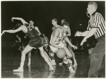 Jerry West swept past Bev Vaughan (25) of William and Mary and scored a total of 38 points against William and Mary. WVU won 85-82 in the semi-finals of the 1959 Southern Conference Tournament.