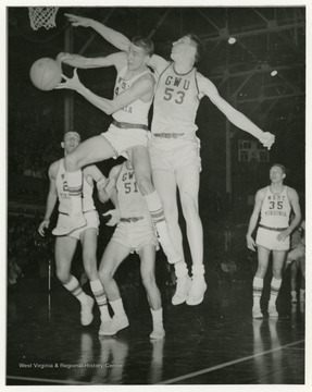 Jerry West and an opponent from GWU both jump toward the basket 