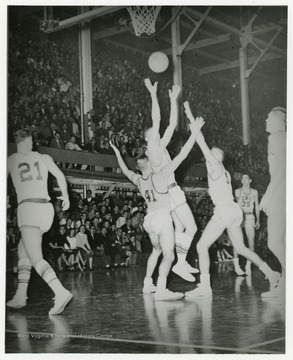 West shoots the ball while opponents attempt to block him during a home WVU game