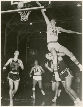 West scores against Canisius's Greg Britz with a back-handed field goal. WVU won the pictured game, 86 - 66.