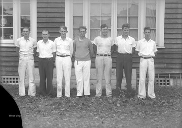 Seven unidentified men pose together.