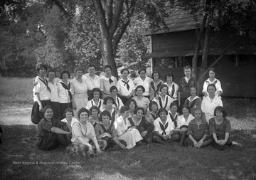 A group of unidentified women pose outside of a 4-H camp. 