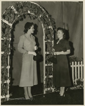 Two unidentified women pose together on stage during the fashion show. 