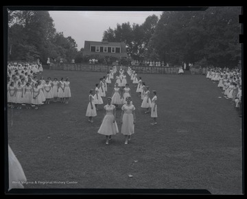 Girls proceed down the field during the ceremony. Subjects unidentified. 