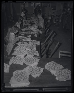 A group of children paint eggs together. Subjects unidentified. 