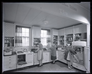 Three unidentified women working in a kitchen that is likely located inside the Jackson's Mill 4-H camp. 