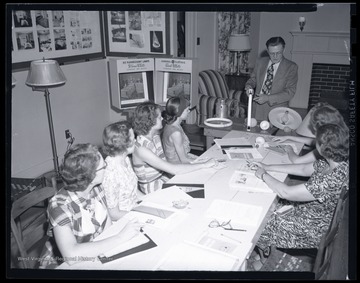 A group of women listen as an instructor demonstrates how to properly change a light bulb. Subjects unidentified.  