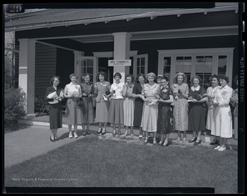 A group of women pose outside of the building. Subjects unidentified. 