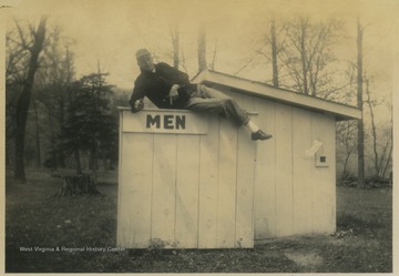 Cooper poses on top of the men's bathroom shack. 